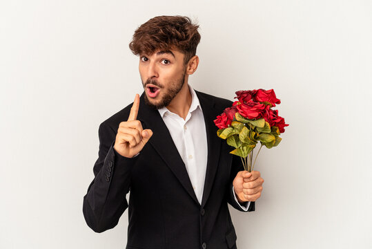 Young mixed race man holding bouquet of roses isolated on white background having an idea, inspiration concept.
