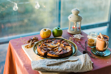 apple pie served on a table with hot chocolate next to a window. Christmas vibes.