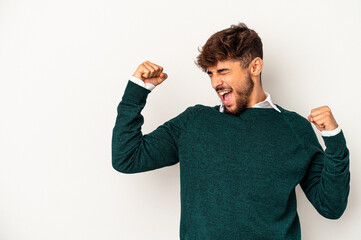 Young mixed race man isolated on grey background raising fist after a victory, winner concept.