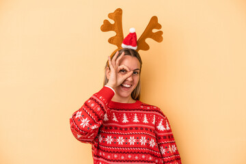 Young caucasian woman wearing a christmas reindeer hat isolated on yellow background excited...