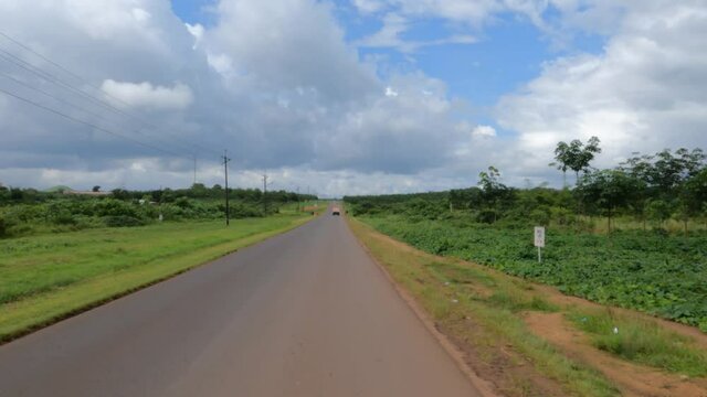Driving road Firestone Liberia rubber plantation and village . West Africa a nation suffers with extreme poverty and hunger. Congested crowded homes, markets, streets and businesses. Tropical climate.