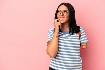 Fototapeta premium Young caucasian student woman with one arm isolated on pink background relaxed thinking about something looking at a copy space.