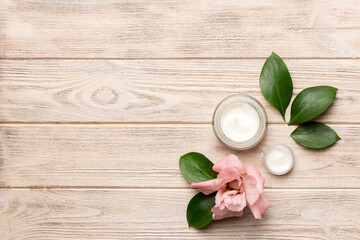 Composition with cosmetic products and beautiful roses on wooden background. Copy space, flat lay