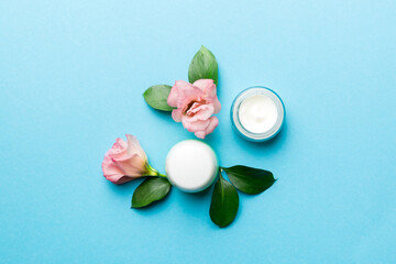 Composition with cosmetic products and beautiful roses on color background. Flat lay