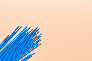 Heap of colorful plastic drinking straws on Colored background, flat lay. Copy Space for text