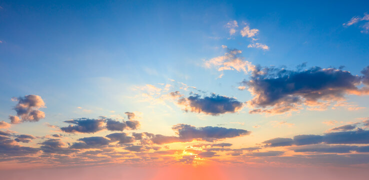 Majestic dramatic sky - sunshine on sunrise sundown sky background with colorful clouds