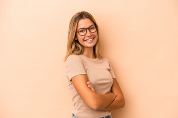 Young caucasian woman isolated on beige background happy, smiling and cheerful.