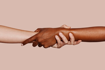 Close up multiracial woman couple with black and caucasian hands holding each other wrist in...