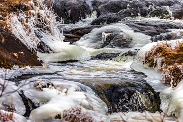 Fast river with ice in late autumn