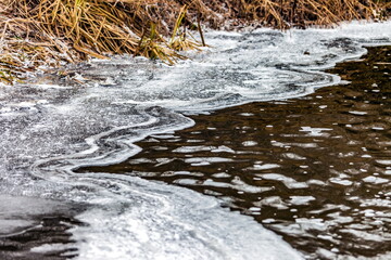 Fast river with ice and snow in late autumn