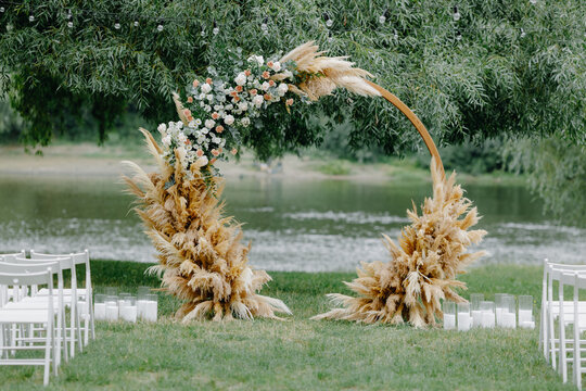 The round wedding arch on the background of the river and greenery
