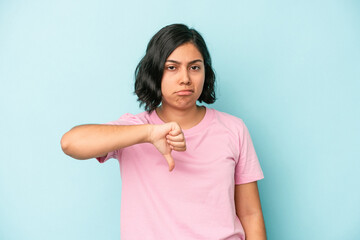 Young latin woman isolated on blue background showing thumb down, disappointment concept.