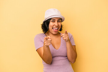 Naklejka premium Young latin woman isolated on yellow background pointing to front with fingers.