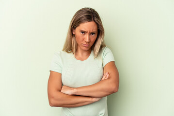 Young caucasian woman isolated on green background unhappy looking in camera with sarcastic expression.