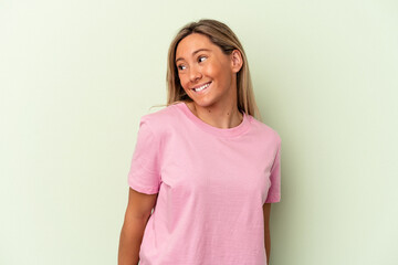 Obraz premium Young caucasian woman isolated on green background laughs and closes eyes, feels relaxed and happy.