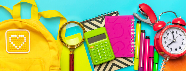 Frame from school and office supplies Paper clips, scissors, pens, felt-tip pens, sharpener, calculator, stapler isolated on blue background Flat lay Top view Back to school, education concept