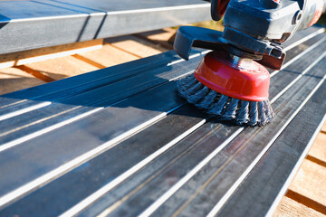 Polishing iron with an electric grinder. Wire brush for cleaning rust off metal surface Wire cleaning brush. Cleaning the metal profile from rust before painting.