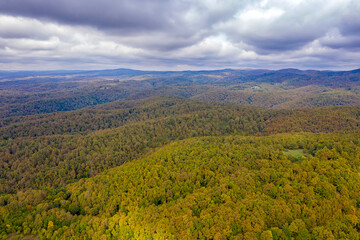 Fototapeta na wymiar Drone Aerial View view of mountain hills. Hilltops covered with autumn forest.
