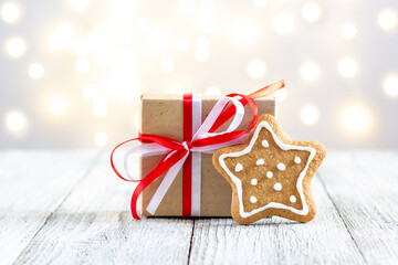 Gingerbread star and box of gift on bokeh lights background