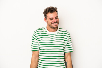 Young caucasian man isolated on white background laughs and closes eyes, feels relaxed and happy.