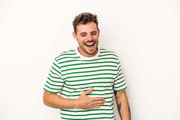 Obraz premium Young caucasian man isolated on white background touches tummy, smiles gently, eating and satisfaction concept.