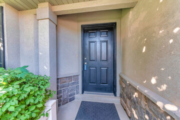 Fototapeta premium Wooden black door exterior with lockbox and black doormat