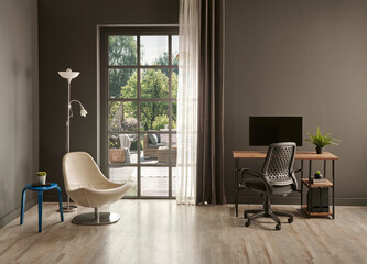 Grey living room office, monitor, chair vase of green plant in front of the window garden view.
