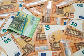  banknotes of 50 euros are laid out and on them are banknotes of 100 euros on the table