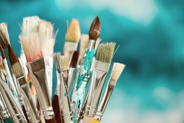 Paint brushes in front of blurred canvas - 467935620