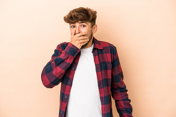 Young arab man isolated on beige background scared and afraid.