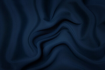 Close-up texture of natural blue fabric or cloth in same color. Fabric texture of natural cotton, silk or wool, or linen textile material. Blue canvas background.