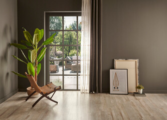 Grey room with window frame and wicket chair, curtain vase of plant.