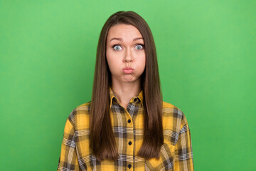 Photo of young glad lady holding breath bog cheeks look camera isolated on green color background