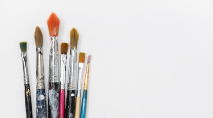 Group of artist brushes on white canvas background. Copy space