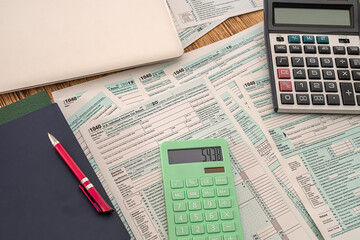 new tax forms 1040 two calculators pen notebook and notebook lie on a wooden table