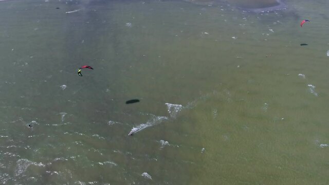 Aerial shot of two athletes windsurfing at the Black Sea beach on a sunny daty