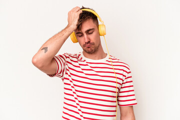 Young caucasian man listening to music isolated on white background being shocked, she has...