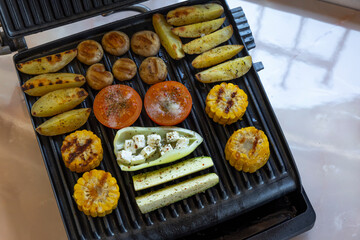 Electric grill with spicy potatoes, mushrooms and vegetables