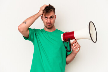 Young caucasian man holding megaphone isolated on white background being shocked, she has remembered important meeting.