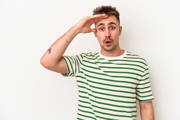 Young caucasian man isolated on white background shouts loud, keeps eyes opened and hands tense.