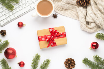 Top view photo of keyboard cup of hot drinking red christmas tree balls pine twigs cones anise sweater and giftbox with red bow on isolated white background