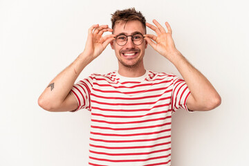 Fototapeta premium Young caucasian man isolated on white background keeping eyes opened to find a success opportunity.