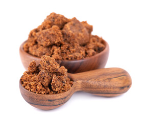 Muscovado sugar in wooden bowl and spoon, isolated on white background. Barbados sugar, khandsari or khand.