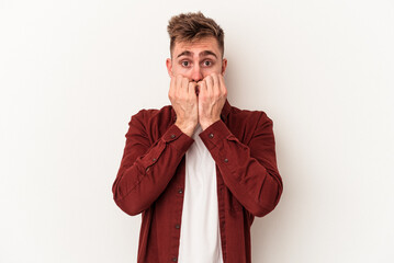 Young caucasian man isolated on white background biting fingernails, nervous and very anxious.