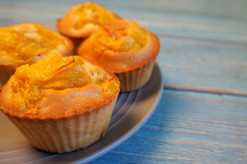 on a gray plate on a blue wooden table are mango muffins with pumpkin, corn and rice flour on the...
