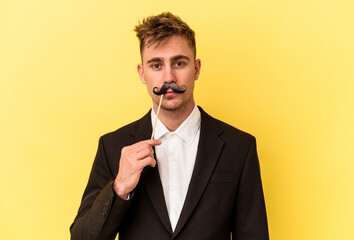 Young caucasian man celebrating new year isolated on yellow background