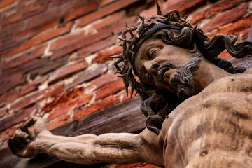 The crucifixion of Jesus Christ as a symbol of God's love. Fragment of an antique statue.