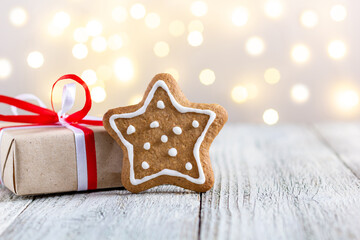 Gingerbread star and box of gift on bokeh lights background