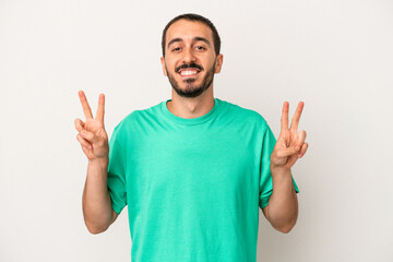 Fototapeta premium Young caucasian man isolated on white background showing victory sign and smiling broadly.