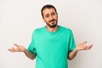 Young caucasian man isolated on white background doubting and shrugging shoulders in questioning...